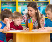 Cute little children drawing with teacher at preschool class