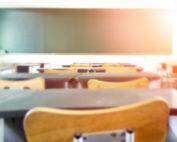 School classroom in blur background without young student; Blurry view of elementary class room no kid or teacher with chairs and tables in campus.