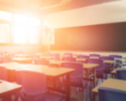 Back to school concept. Classroom in blur background without young student; Blurry view of elementary class room no kid or teacher with chairs and tables in campus.